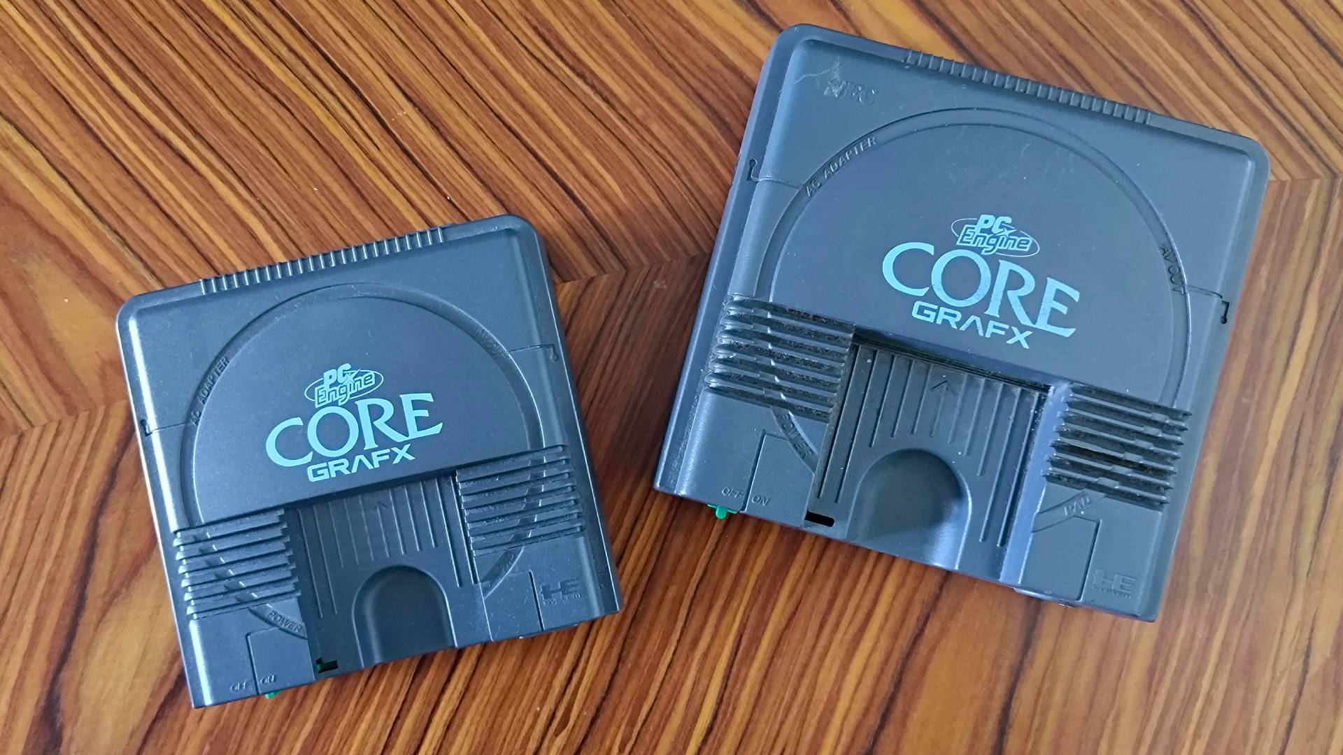 PC Engine mini next to original console on woodgrain table.